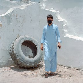 worker standing next to a tire in covid