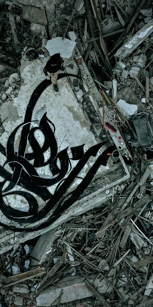 calligraphy in black on a broken wall