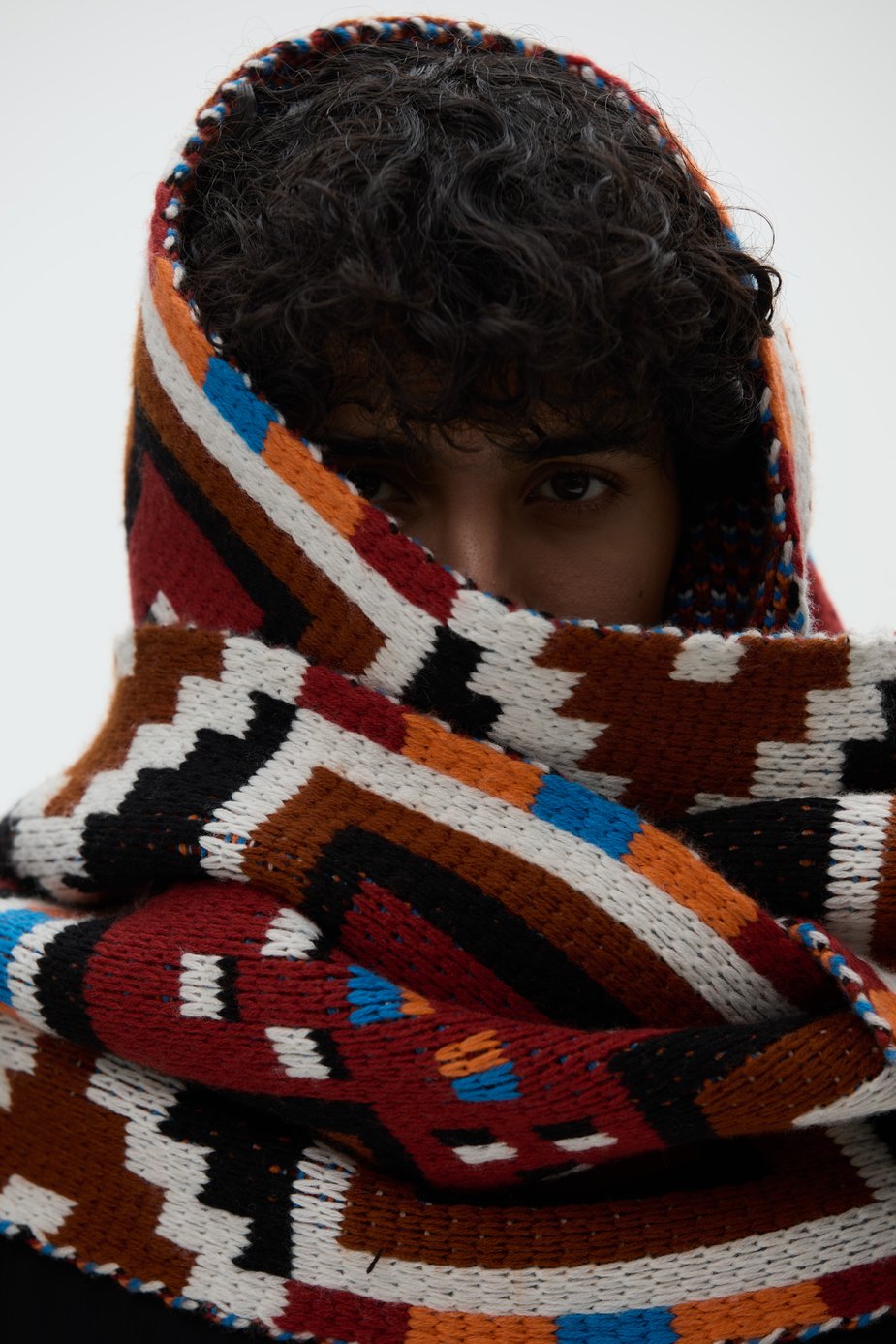 Person with curly hair wearing a thick scarf around her head