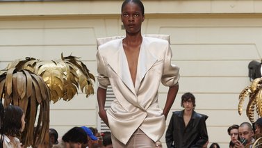Model on the runway in a beige suit