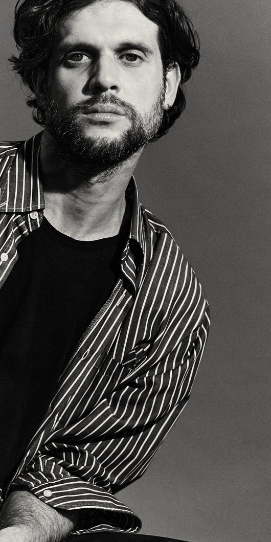 Black and white portrait of designer with striped blouse