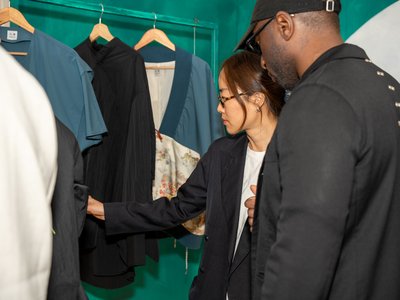 People looking at garments hanged on a rail