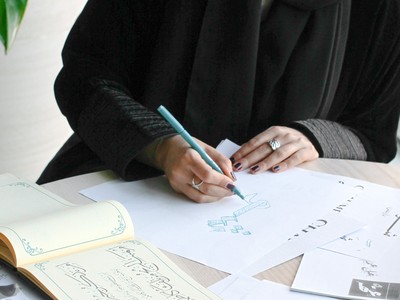 Sketches and someone doing Arabic calligraphy