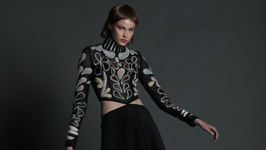 Model wearing a top and long black skirt