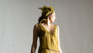 Model posing in a short yellow dress