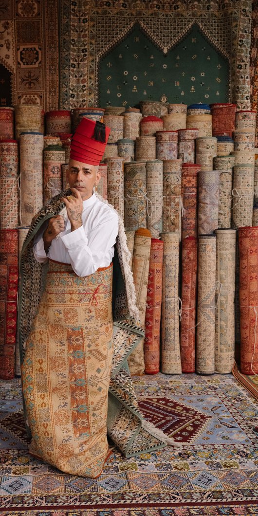 Designer posing in front of fabrics