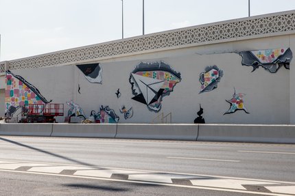 جدارية تجسّد أوراقاً ممزقة ومتناثرة وتظهر ايضاً طائرة ورقية