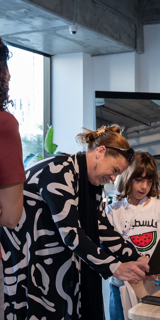 Two adults discussing kids artwork at a workshop