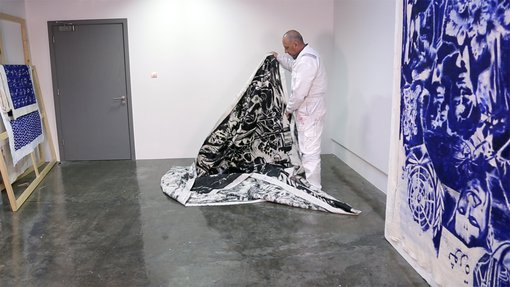 Visiting Artist Nedim Kufi holding and creating sculptural forms using with his painting, in his studio at the Fire Station.