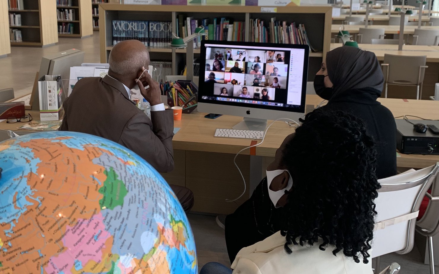 A man and a woman sitting in front of a computer inside MIA hosting a Planet Kids event on Zoom