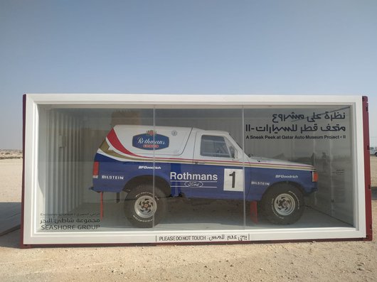A blue and white 1990 Ford Bronco XLT in a display case.