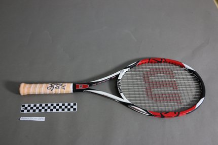 A black, red and white Wilson racquet signed by renowned tennis player Roger Federer.