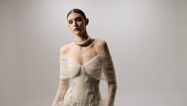 Model body facing away from the camera but face looking into the camera
