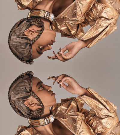 Mirror of a model wearing gold jacket and couture braids