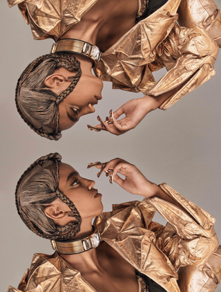 مرآة عارضة أزياء ترتدي سترة ذهبية وضفائر راقية