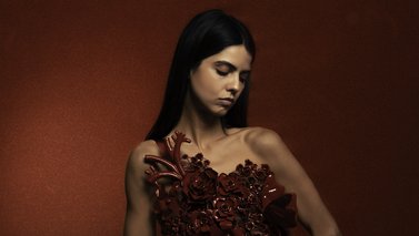 Model posing in a dark red setting