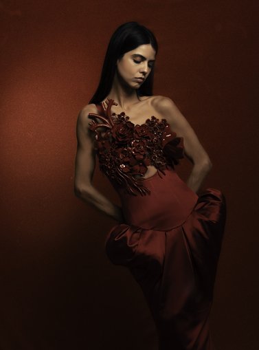 Model posing in a dark red setting