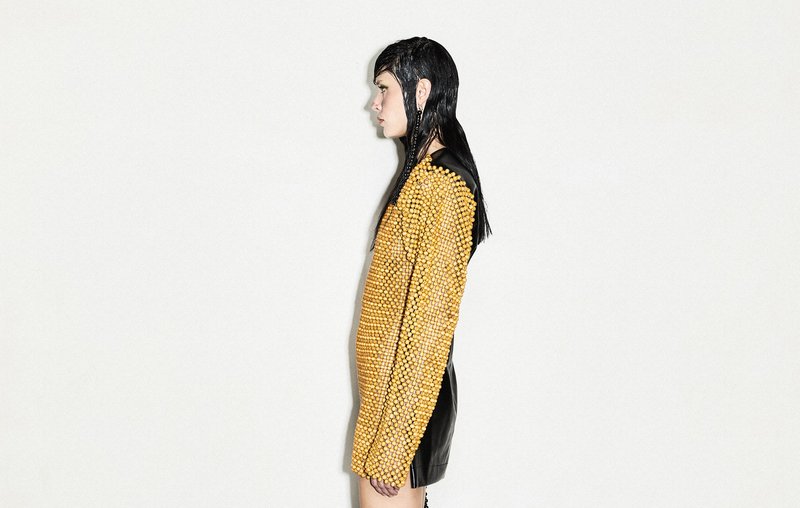 Model facing sideways yellow jumper