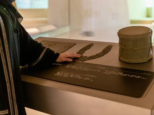 Woman using tactile accessible information panels at NMoQ