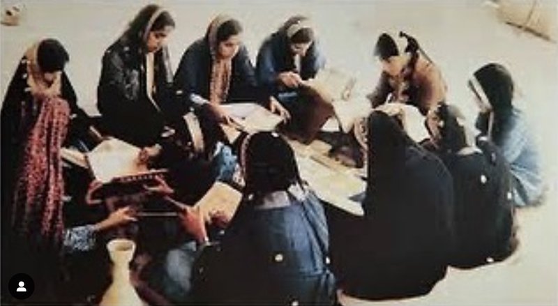 An old photograph showing Amna Mahmoud Al Jaidah teaching a group of female students.