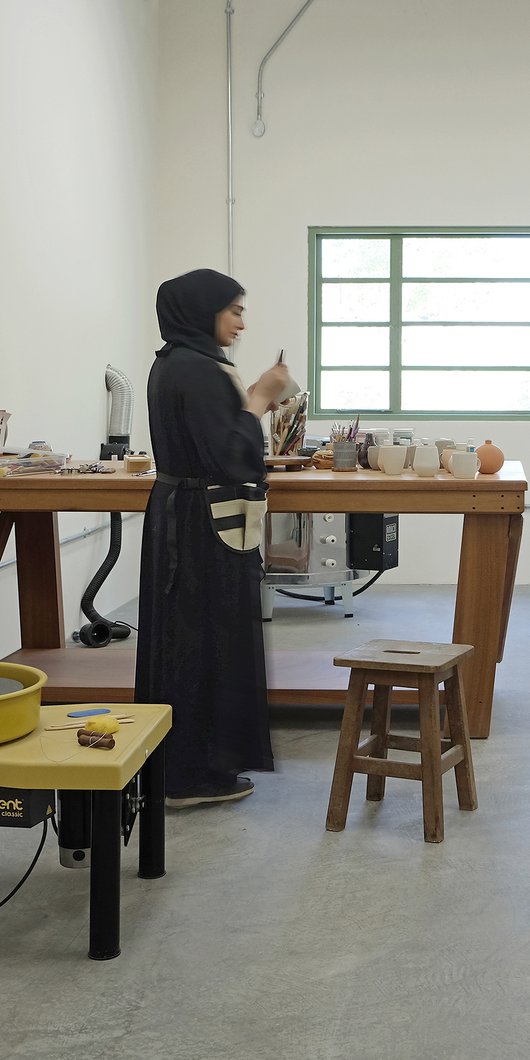 Interior view of clay lab with equipment and a woman standing.