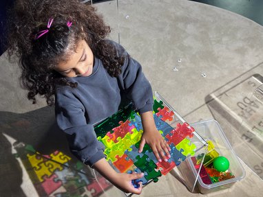 Girl playing with puzzle pieces