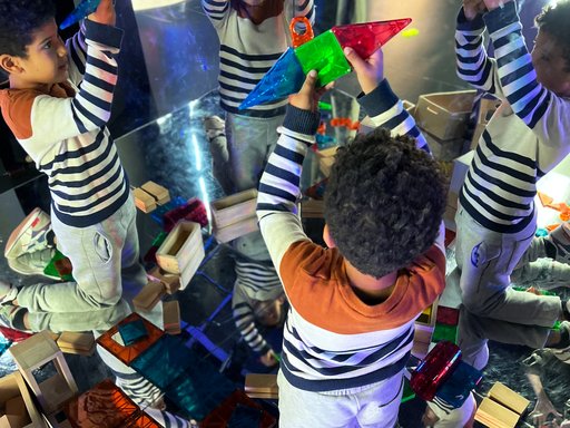 Children playing with magnetic building blocks to create interesting shapes