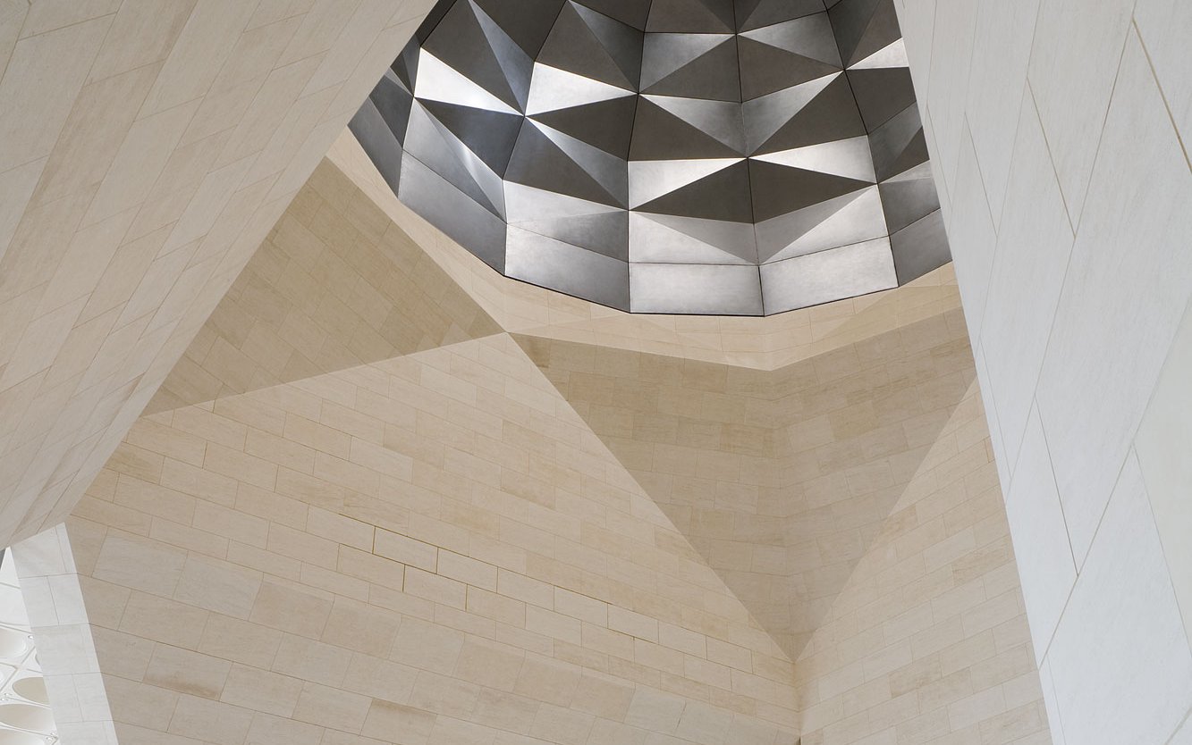 View showing interior of the Museum of Islamic Art with angular marble walls and decorative ceiling dome