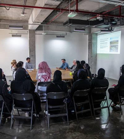 A group of interns sit around a table as they listen to the instructor
