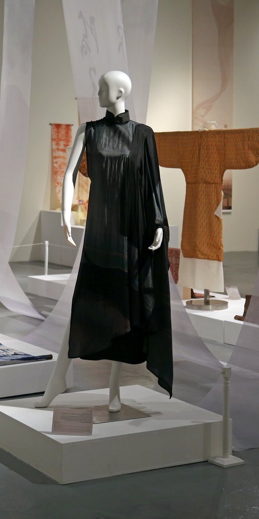 A shot of mannequins in colourful artistic dresses with additional  printed fabrics hanging in the background