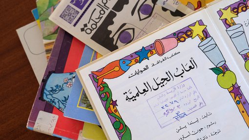 A pile of colourful vintage Arabic school books in Liwan's library.