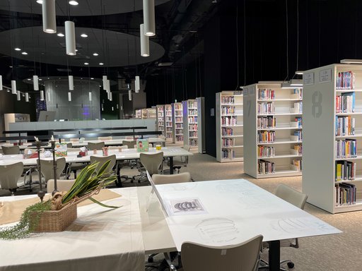 Rows of desks and shelving units at the QOSM library.