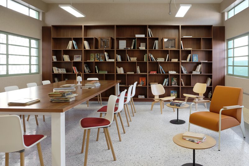 Library with children books and a conference-style table with chairs.