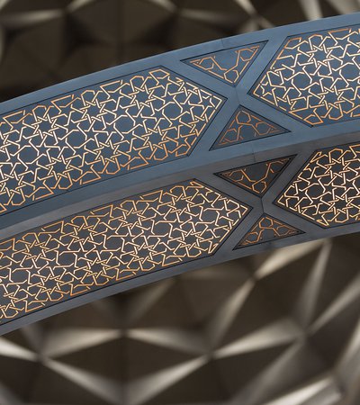 Detail of decorative lighting showing geometric patterns and the large ceiling dome in the background