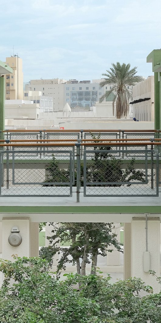 Elevated view looking across Liwan's courtyard with a tree and cross-walk.