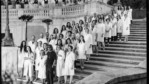 A group of people in white coats standing on the Spanish Steps in Rome.