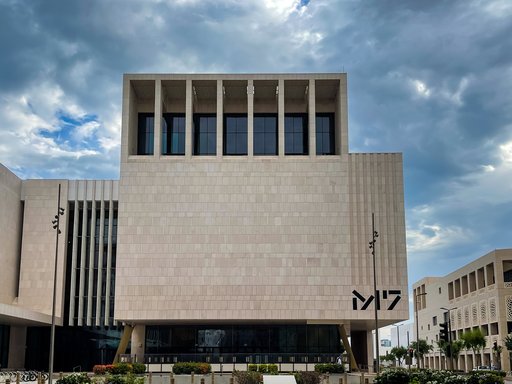 The geometric architecture of M7 and hexagonal tiled flooring against a cloudy Doha sky