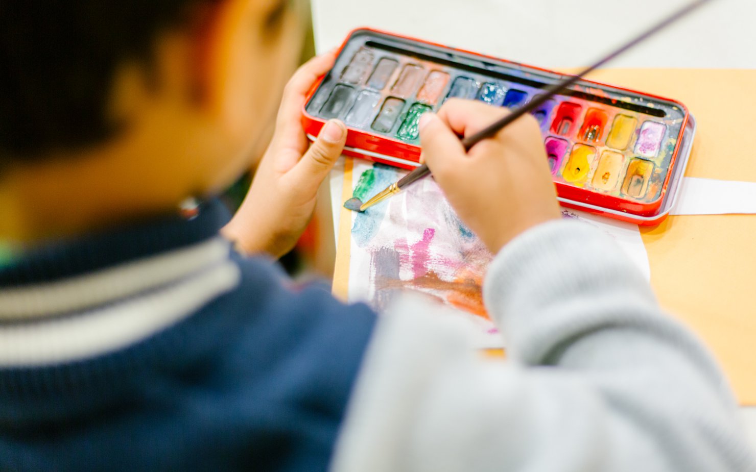 A child paints with watercolours