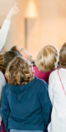 A teacher surrounded by children is giving a school tour at the Museum of Islamic Art