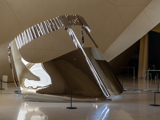 Large-scale shiny silver metallic sculpture depicting a 'niqab', a traditional face covering