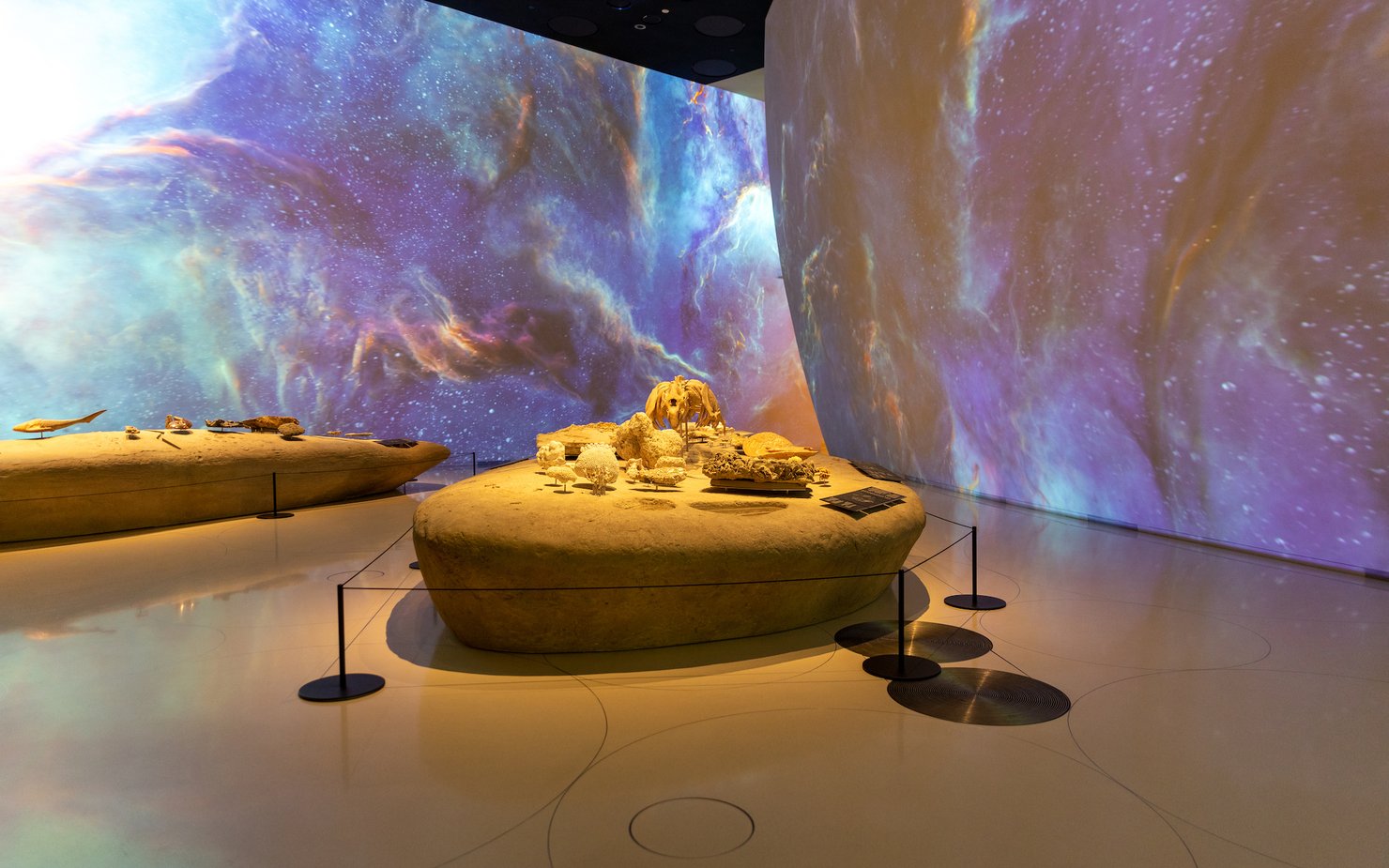 Interior of a gallery space at the National Museum of Qatar with galaxy projection on the walls
