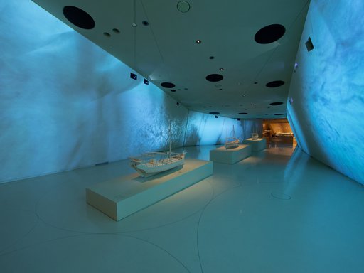 Interior of a gallery space at the National Museum of Qatar showcasing traditional dhow boats