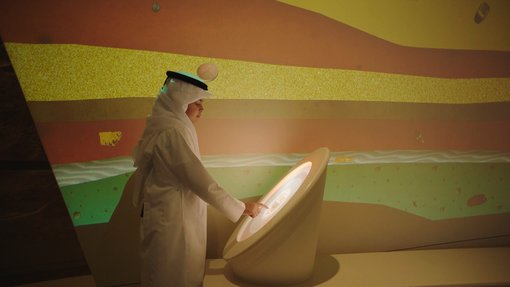 طفل في الزي التقليدي القطري يتفاعل مع شاشة رقمية في متحف قطر الوطني