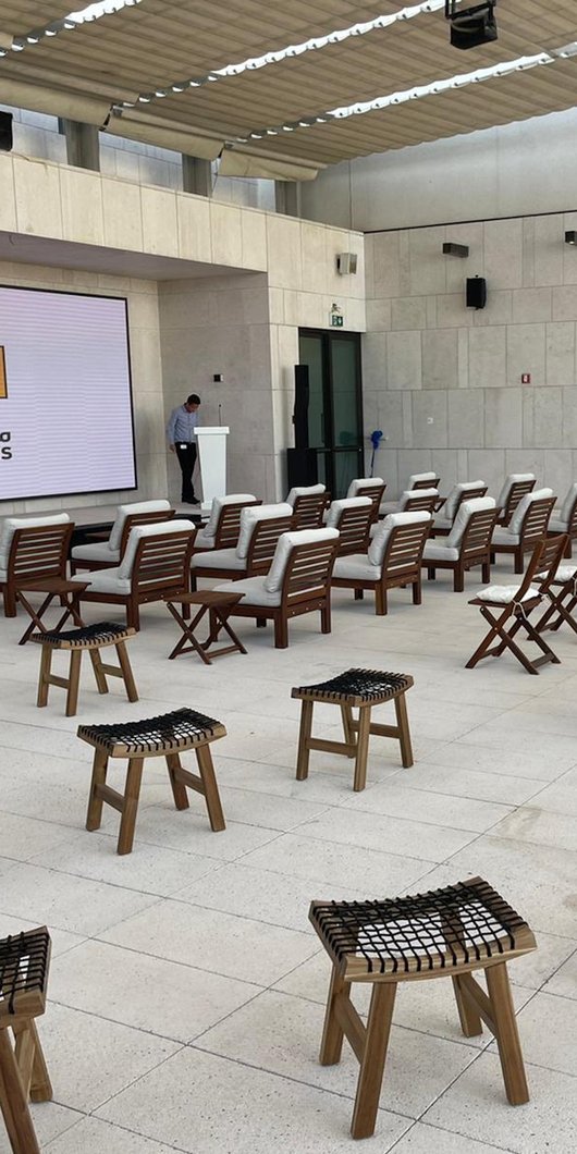 An open air space with a large projection screen and rows of empty seating.