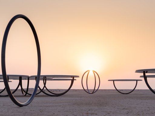 Circular shelters and rings placed in a desert landscape