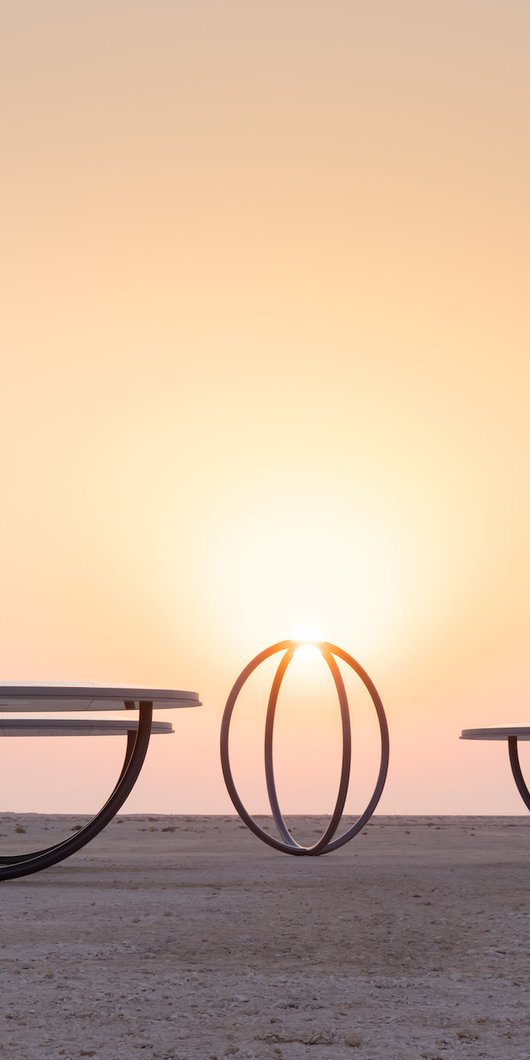 Circular shelters and rings placed in a desert landscape