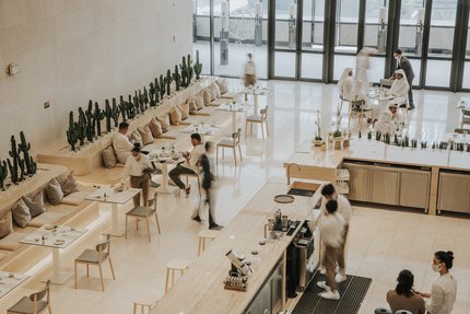 Viewed from above, a modern café interior with customers and staff.