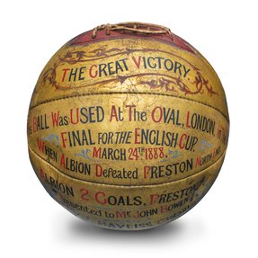 A golden coloured football with text that reads 'This ball was used at the Oval, London, in the final for the English Cup, March 24th 1888.