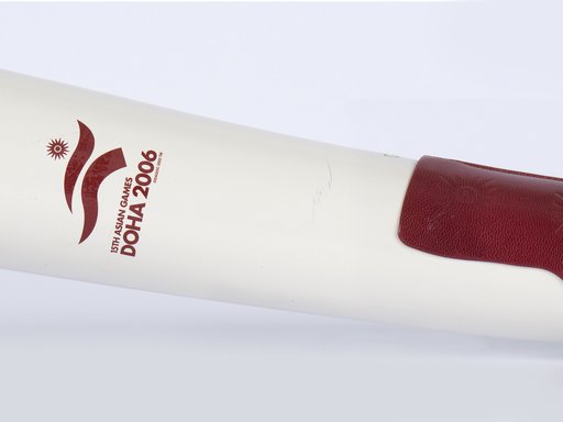 A horizontal white torch with a burgundy leather strap and the logo of Doha 2006 Asian Games