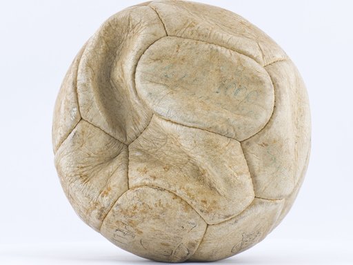 A white football, time-weathered leather, with faint blue writing visible.